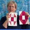 woman holding quilt blocks