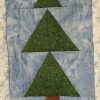 Tree Block from Holidaze Sampler quilt block with green tree on a blue background
