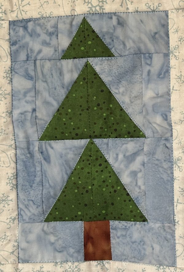 Tree Block from Holidaze Sampler quilt block with green tree on a blue background